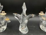 three clear glass candlesticks with gold candles in them
