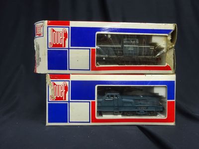 two boxes of toy trains sitting on a black surface