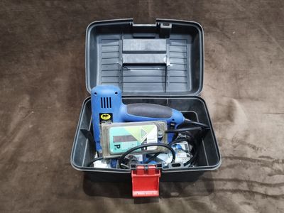 une trousse à outils dans un coffret en plastique posé sur le sol