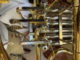 a close up of a brass instrument with a person standing next to it