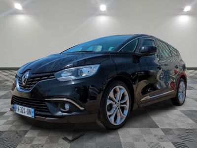 La voiture noire est garée sur un sol en dalles à damier.
