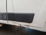 a close up of a white truck with a flat tire