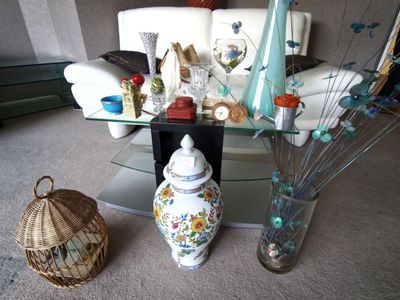 une table en verre sur laquelle sont posés un vase et d'autres vases, dans un salon