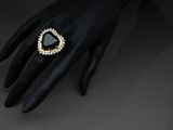 a woman ' s hand with a black diamond ring on it