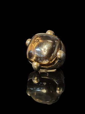 a close up of a gold ring on a black surface