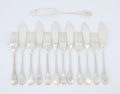 six fourchettes et un couteau sont alignés sur une surface blanche