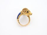 un gros plan d'une bague en or ornée d'une tête de bélier