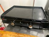 une plaque de cuisson noire posée sur une table en bois
