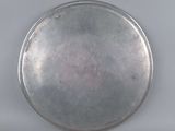 a silver plate on a table with a white background