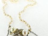 collier avec des perles et un pendentif en forme de feuille sur fond blanc