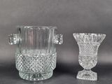 une paire de vases en cristal taillé munis d'anses, posés sur une table
