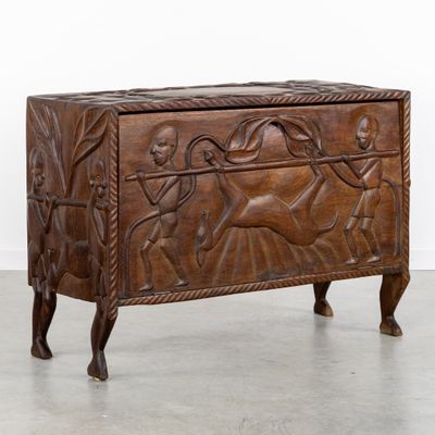 un vieux coffre en bois orné de sculptures, dans une pièce