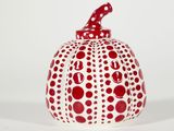 a red and white polka dot pumpkin on a white surface