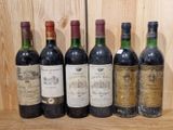six bouteilles de vin sont alignées sur une étagère devant un mur en bois