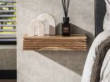 une étagère en bois fixée au mur à côté d'un lit