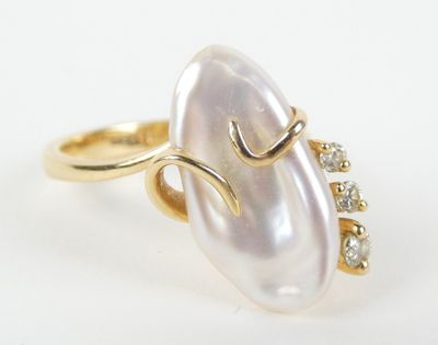 gros plan d'une bague en perles et diamants sur une surface blanche
