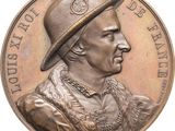 un gros plan sur une médaille de bronze représentant un homme coiffé d'un chapeau