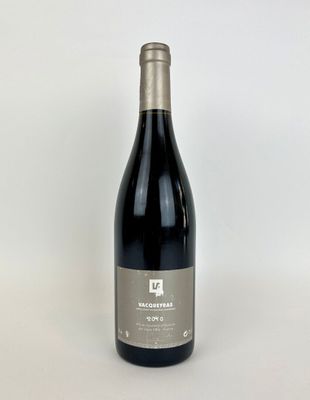 une bouteille de vin rouge posée sur une table blanche