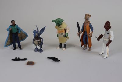 cinq figurines représentant différents personnages posées sur une surface blanche