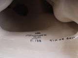 underside view of a white porcelain sculpture of a man with a hat on