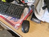 a desk with a keyboard, mouse, and other items on it