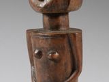une figurine en bois représentant une femme coiffée d'une coiffe