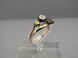 an image of a gold and diamond ring on a clear stand