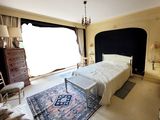 une chambre avec un grand lit et un lustre