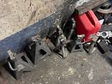 a red gas can sitting on the ground next to a pile of clamps