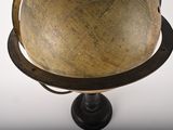 a wooden globe on a stand with a black base