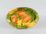 a yellow and red bowl with orange flowers on it
