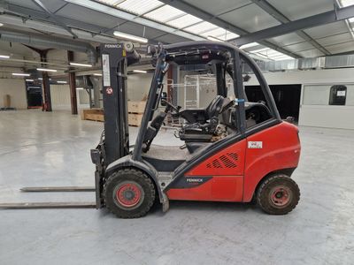 un chariot élévateur rouge garé dans un entrepôt