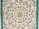 une écharpe carrée verte et blanche ornée d'un motif représentant des oiseaux