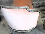 une chaise rose qui se trouve au milieu d'une pièce