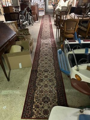 un long tapis au milieu d'une pièce remplie de meubles