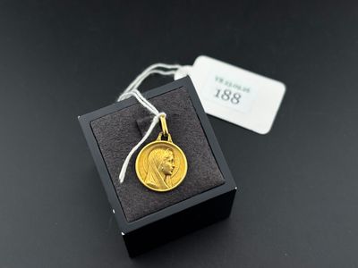 une pièce d'or dans une boîte noire sur laquelle est accrochée une étiquette