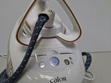 a white and gold steam iron sitting on a table