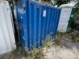 a blue container sitting in the middle of a dirt field