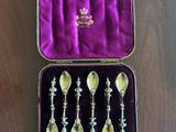 four spoons in a purple case on a wooden table