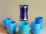 cinq tasses et un vase posés sur une table