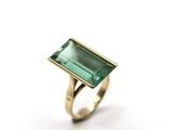Gros plan sur une bague ornée d'une pierre verte