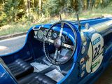a close up of a blue race car with a steering wheel