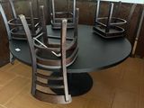 a black table with four chairs and a microwave in the corner