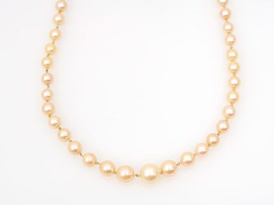 un collier en or orné de perles et doté d'un fermoir en diamant