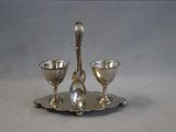 a silver plate with two spoons and two glasses on it
