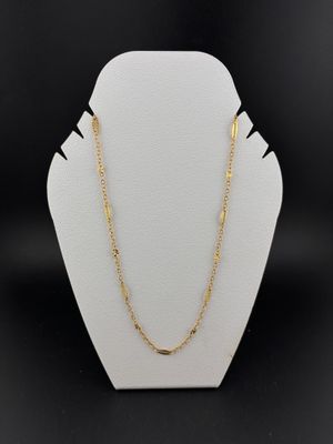 a gold chain necklace with a gold clasp on a white mannequin
