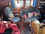 un salon avec un canapé, un fauteuil et une bibliothèque