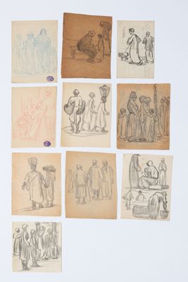 Plusieurs dessins représentant des personnes sont exposés sur du vieux papier posé sur une table