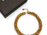 chanel multicolored woven bracelet with red, green, and gold beads