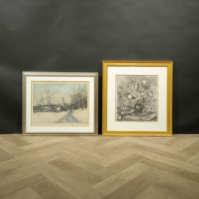 deux tableaux encadrés posés sur un parquet, devant un mur noir